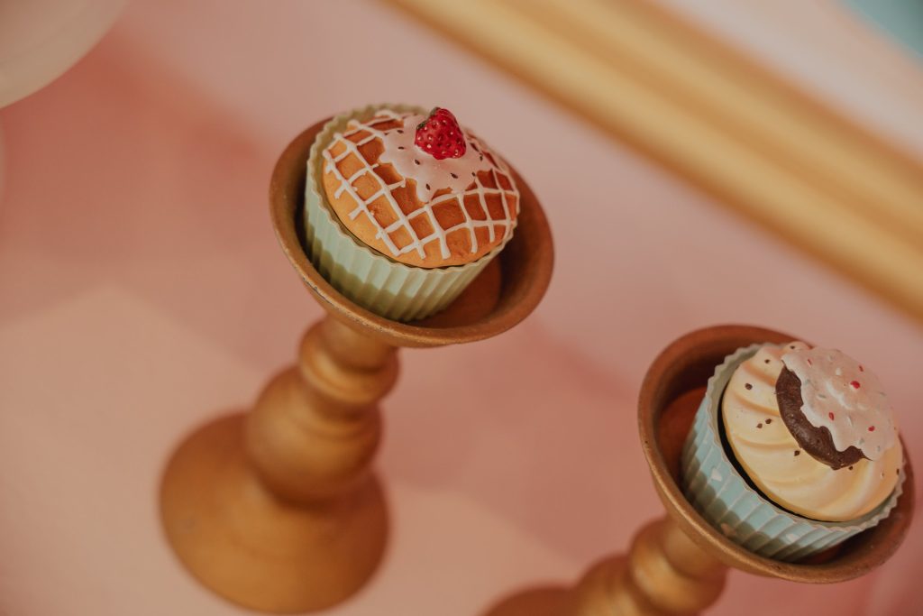 Mini cupcake su alzatine dorate nella vetrina della pasticceria