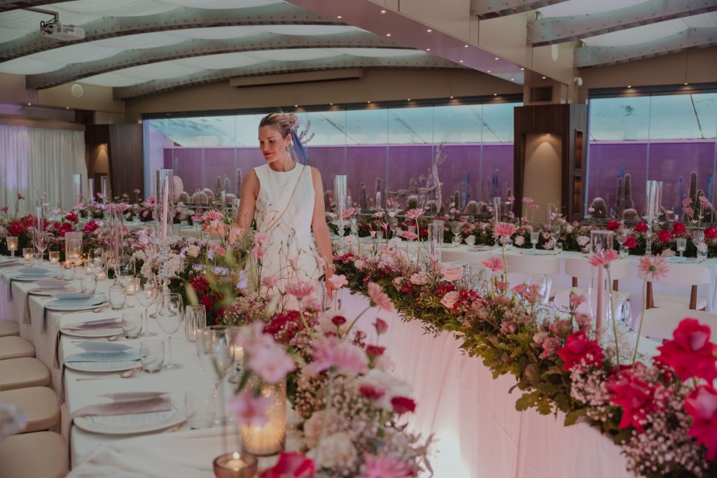 La sala con i tavoli imperiali e le composizioni di fiori rosa e rossi