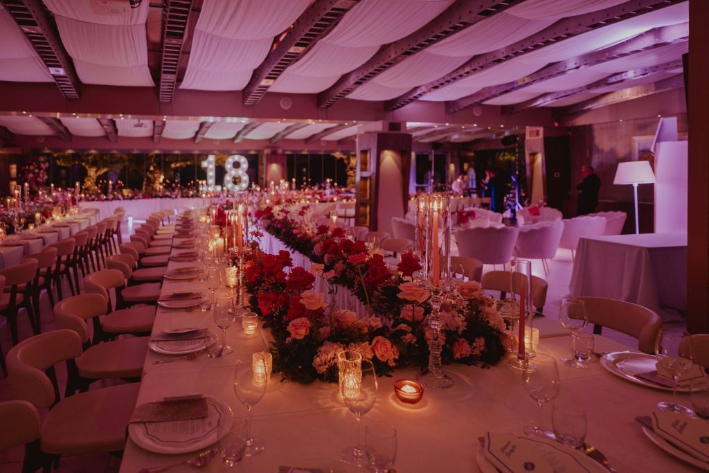 La sala allestita per la cena, con candele, fiori e il 18 luminoso in fondo