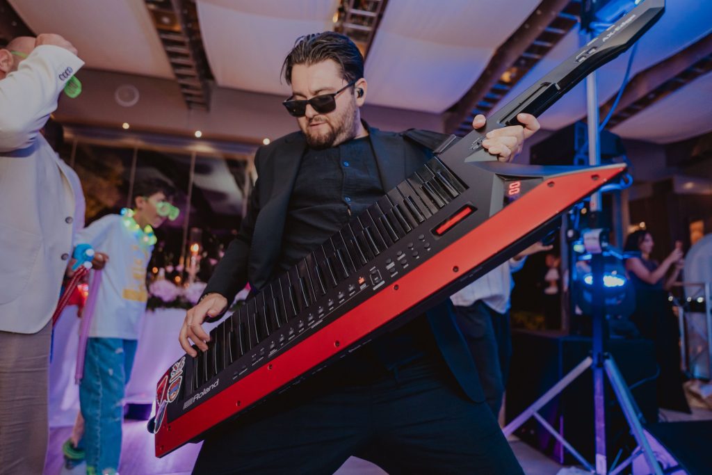 Il tastierista della band suona la keytar rossa in mezzo agli ospiti