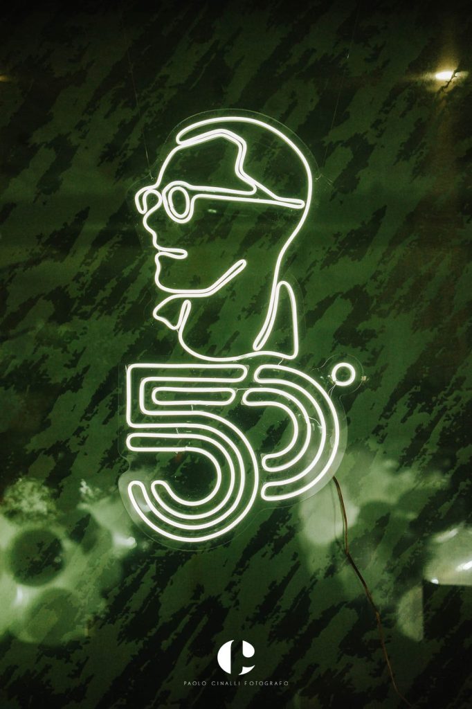 Insegna al neon con il ritratto stilizzato di Angelo e il numero 50