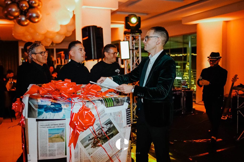 Angelo scarta un regalo gigante incartato con i giornali