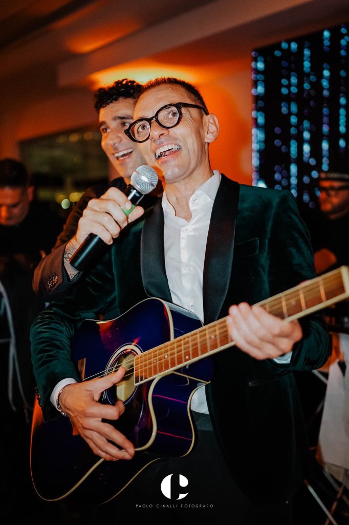 Angelo canta con un amico che suona la chitarra