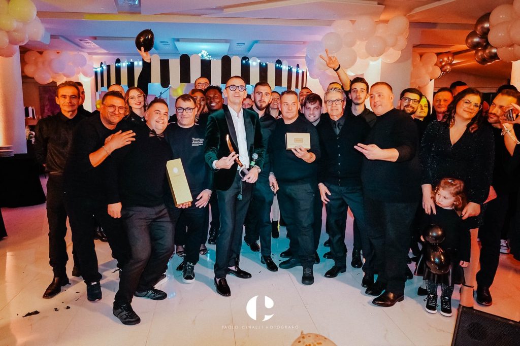 Foto di gruppo di Angelo con amici e ospiti in sala