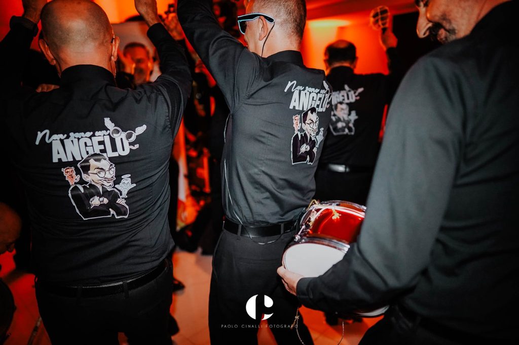 Gli amici con la camicia “Non sono un angelo” suonano in mezzo alla festa