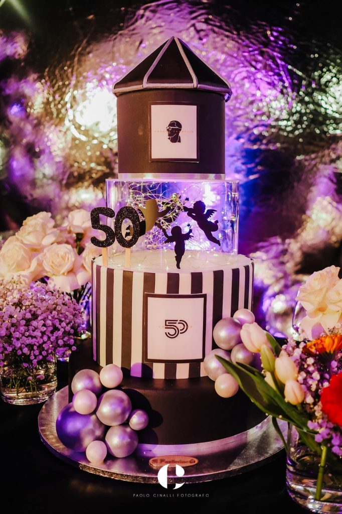 La torta a forma di giostra, a strisce bianche e nere, con gli angioletti e il 50