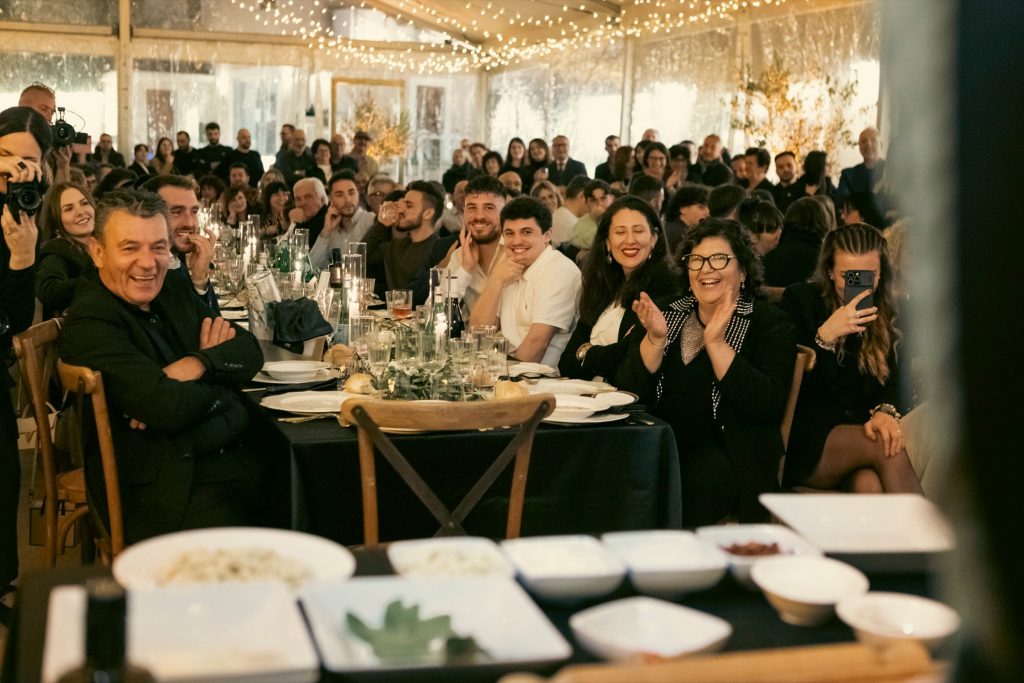 Gli ospiti a tavola applaudono durante la serata